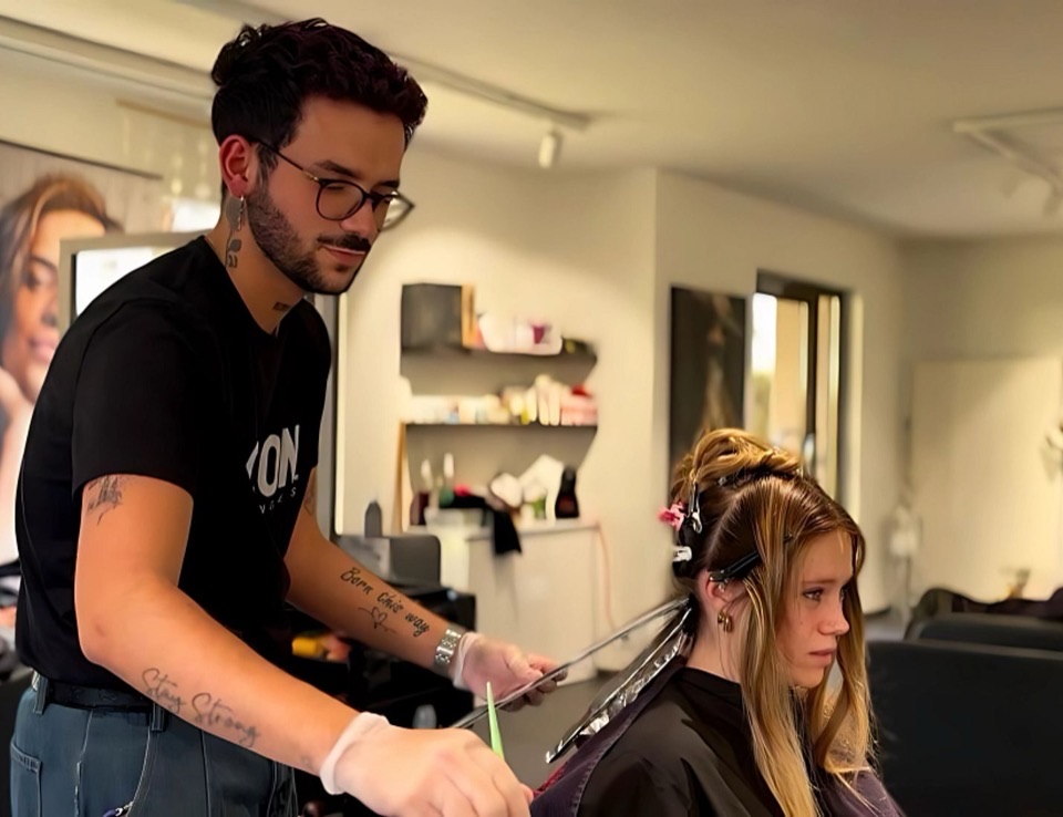 Lorenzo en plein travail, posant un balayage mèche par mèche sur une cliente