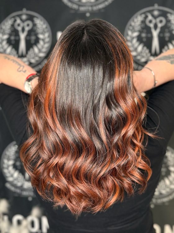 Balayage cuivré sur base brune, boucles marquées